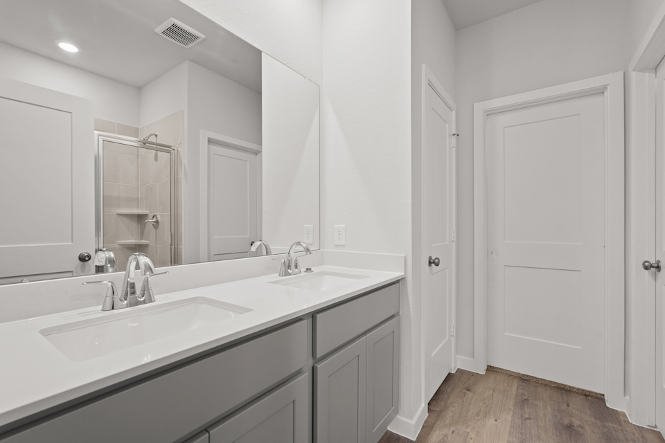 A bathroom with white cabinets.