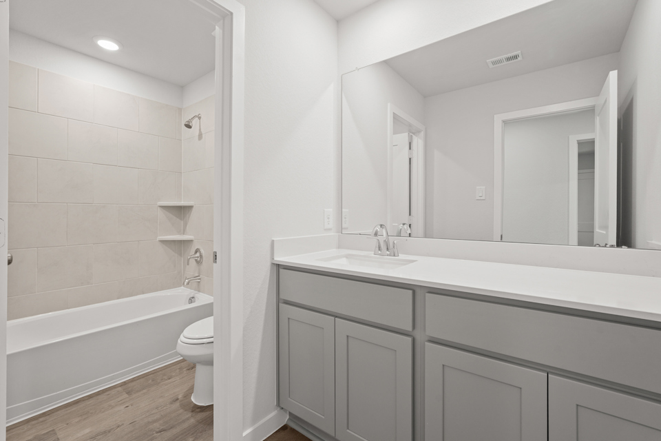 A bathroom with a tub sink and toilet.