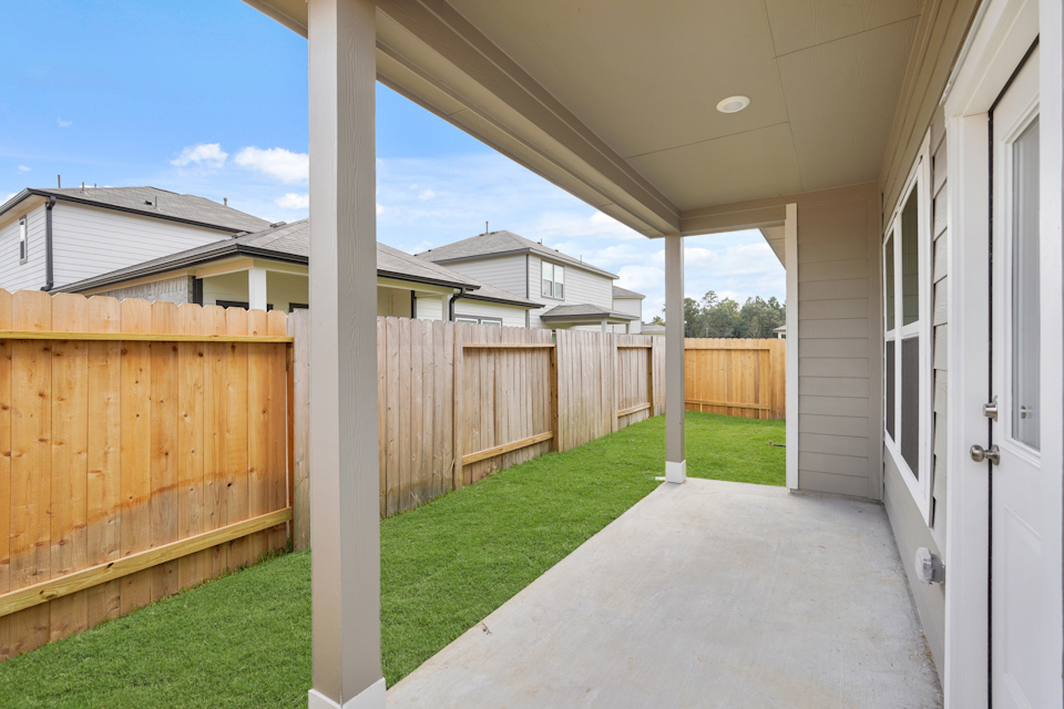 A fenced in yard with a house in the background.
