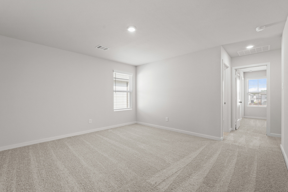 A room with a carpet and windows.