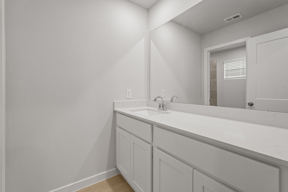 A bathroom with a large mirror.