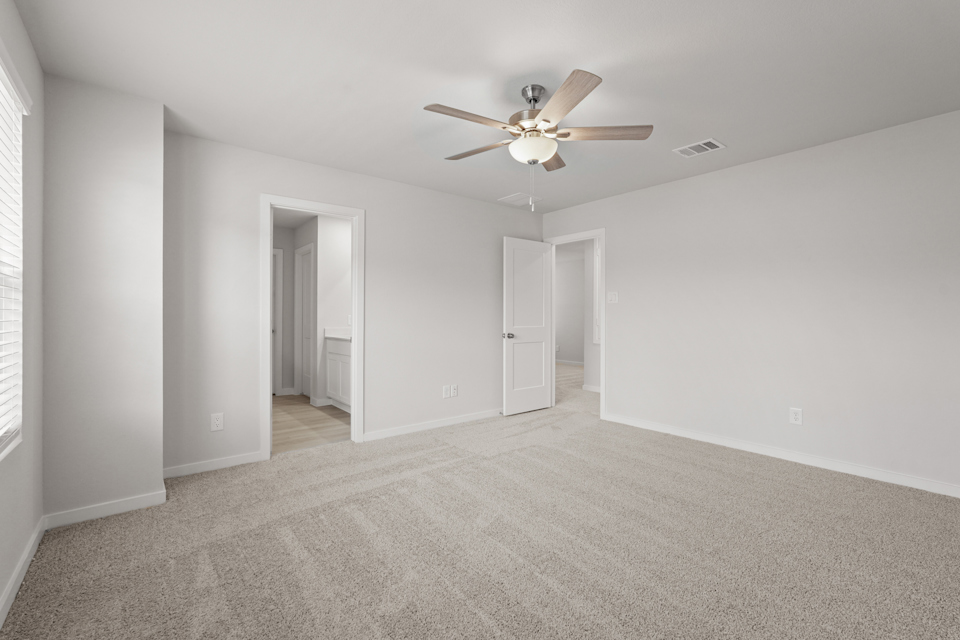 A room with a ceiling fan and a door.