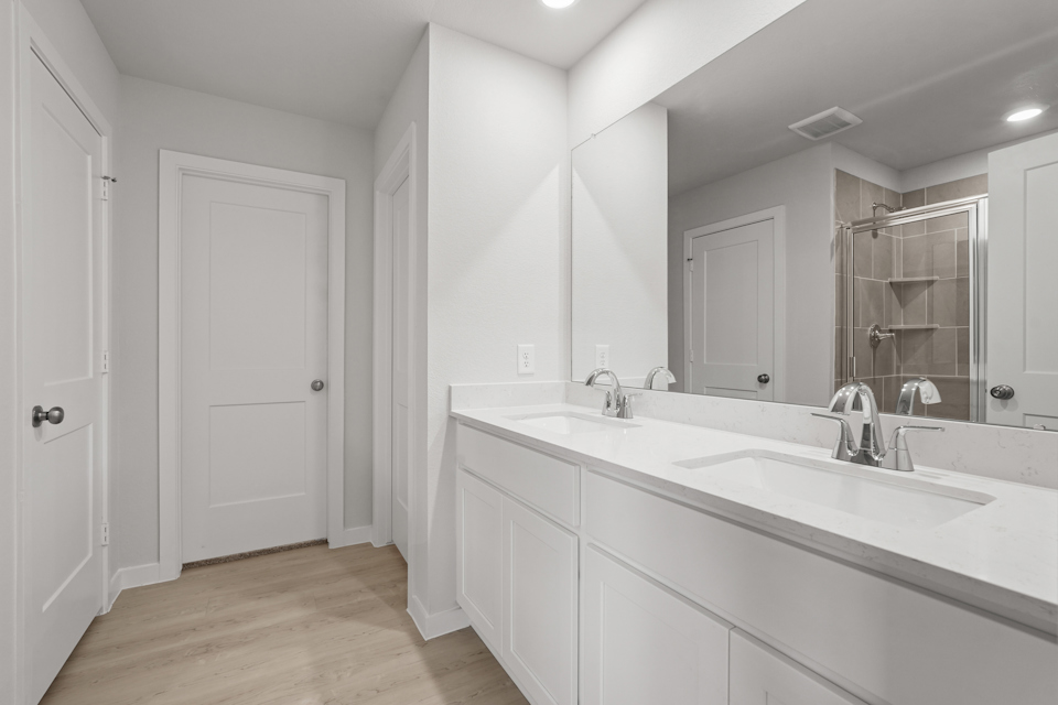 A bathroom with white cabinets.