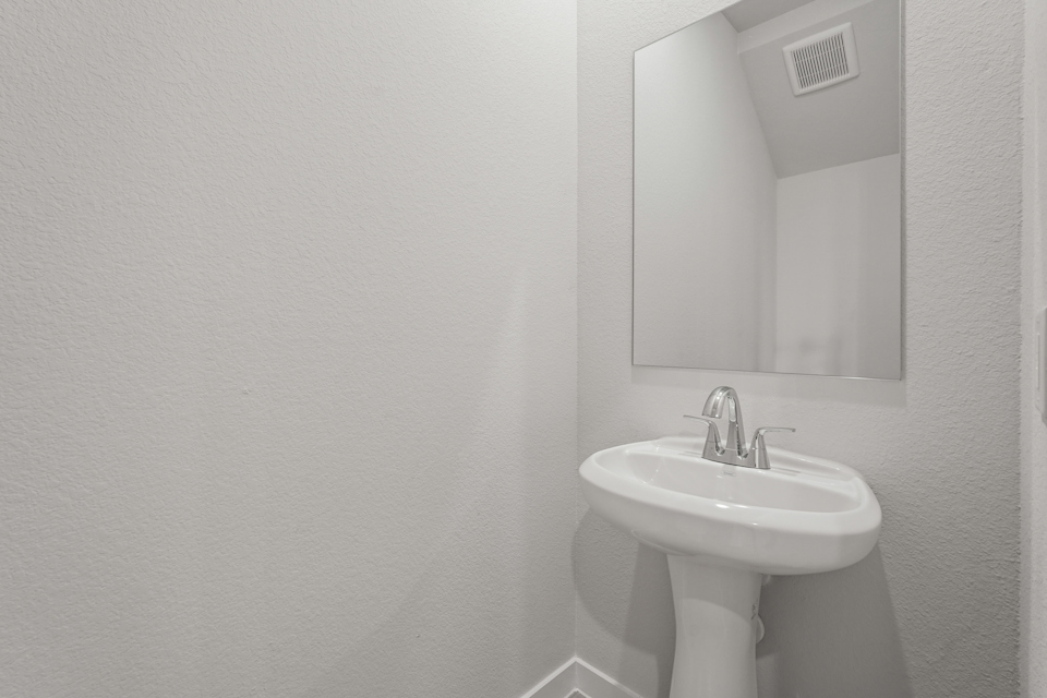 A bathroom with a mirror and sink.