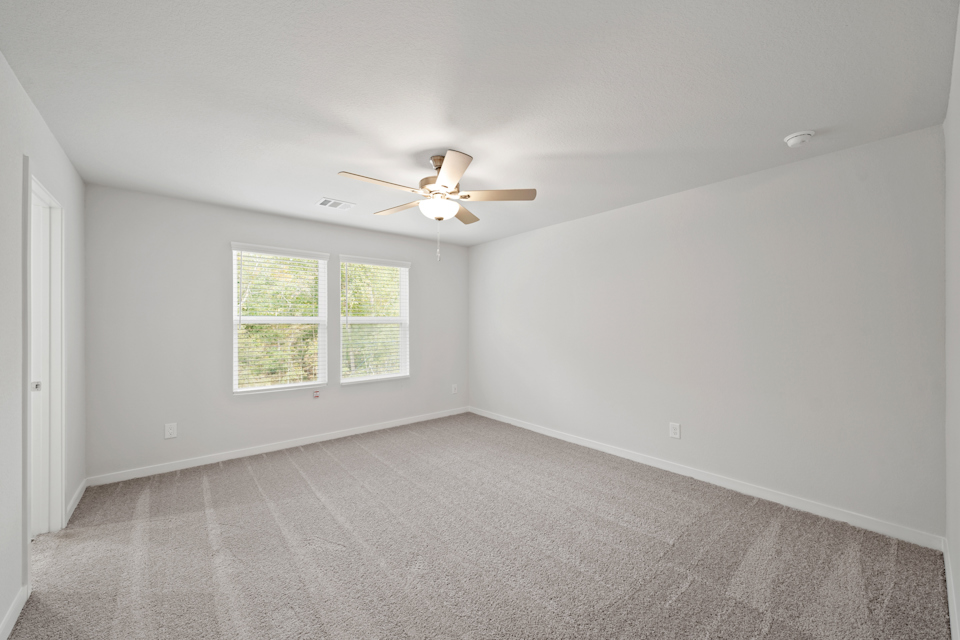 A room with a ceiling fan and a window.