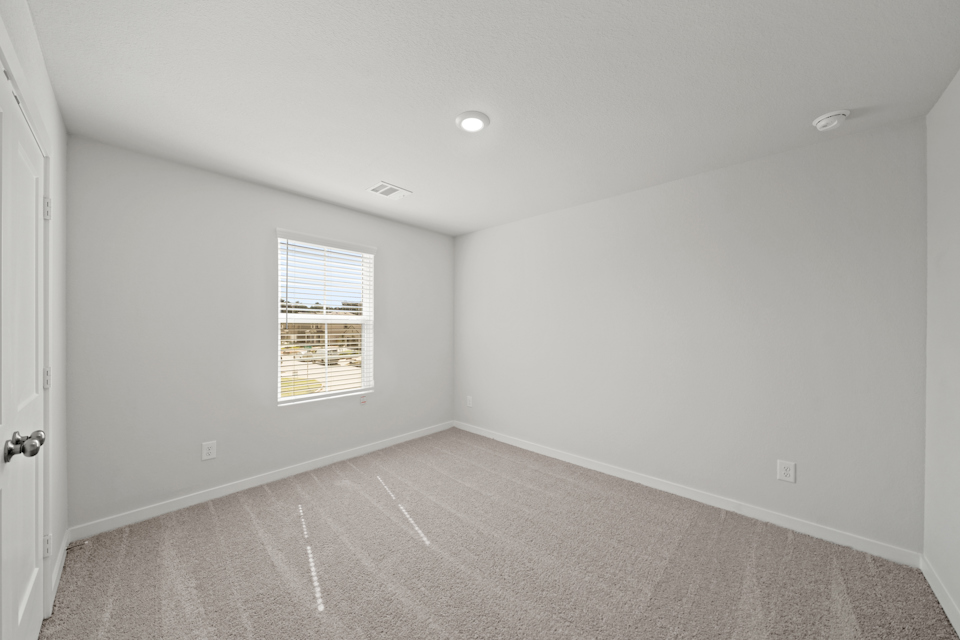 A room with a window and a carpet.