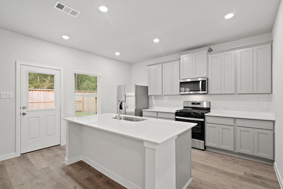 A kitchen with white cabinets.