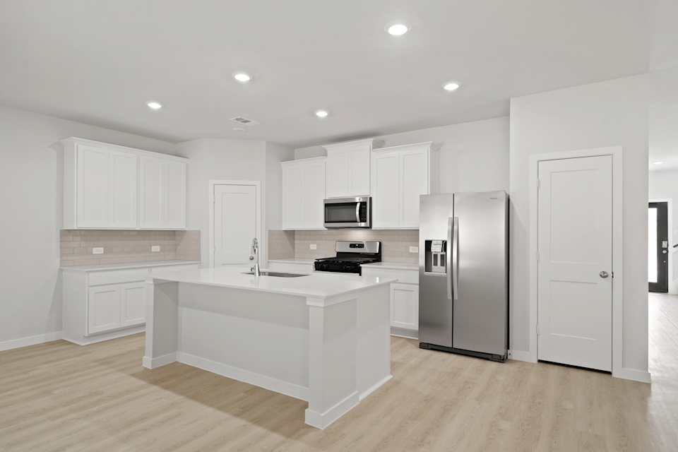 A kitchen with white cabinets.