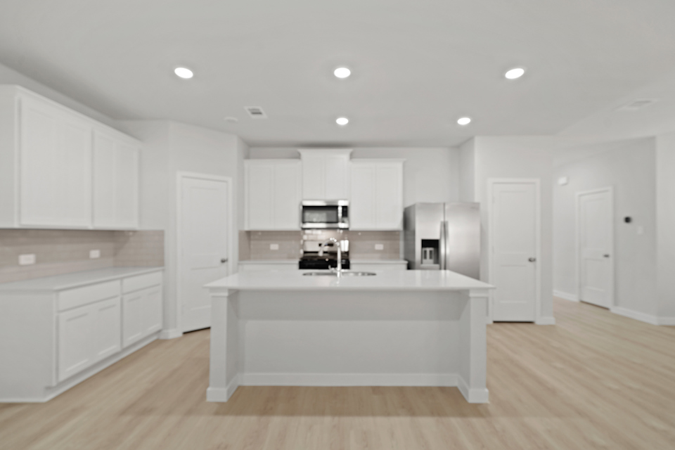 A kitchen with white cabinets.