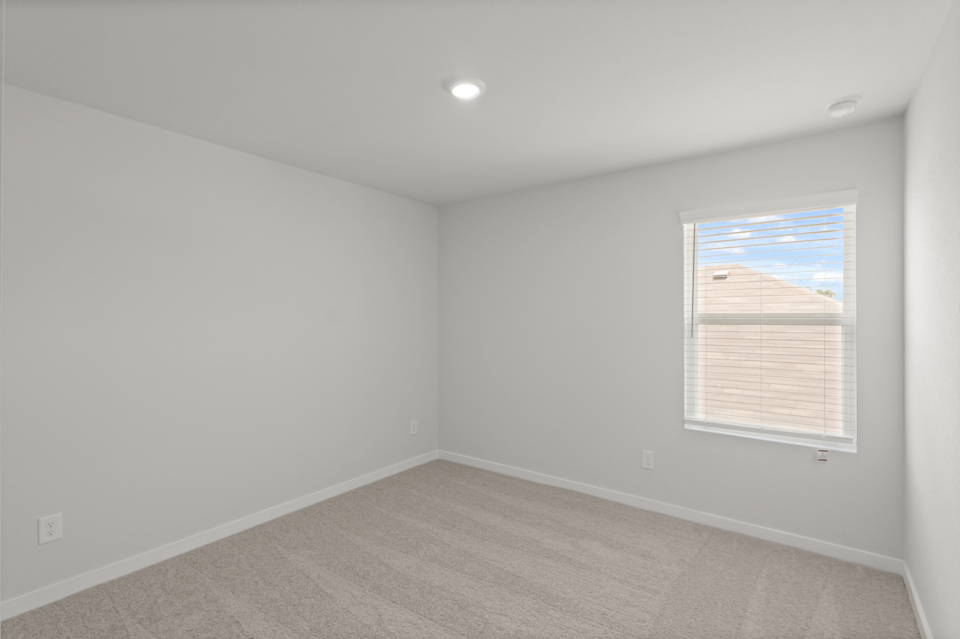 A room with a window and a carpet.