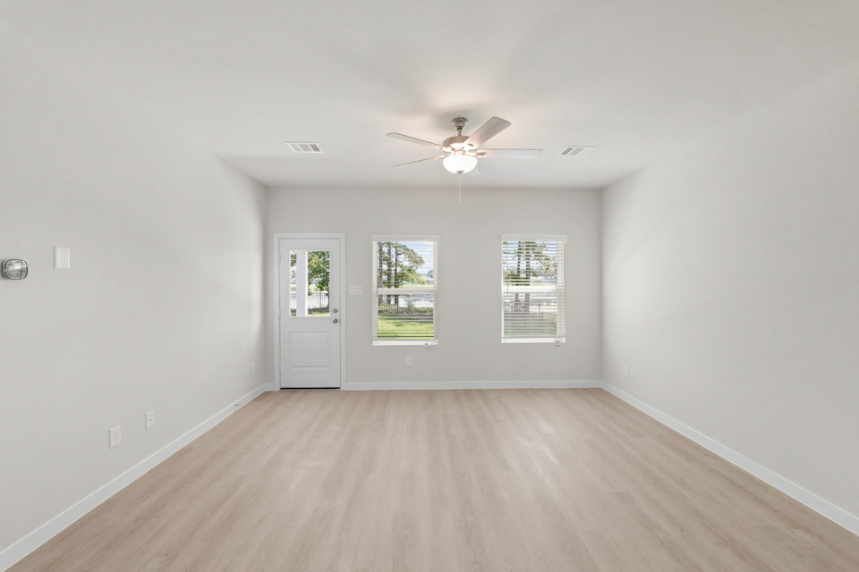 A room with a wood floor and a ceiling fan.