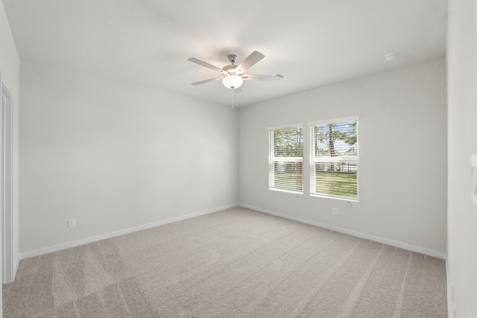 A room with a ceiling fan and a window.