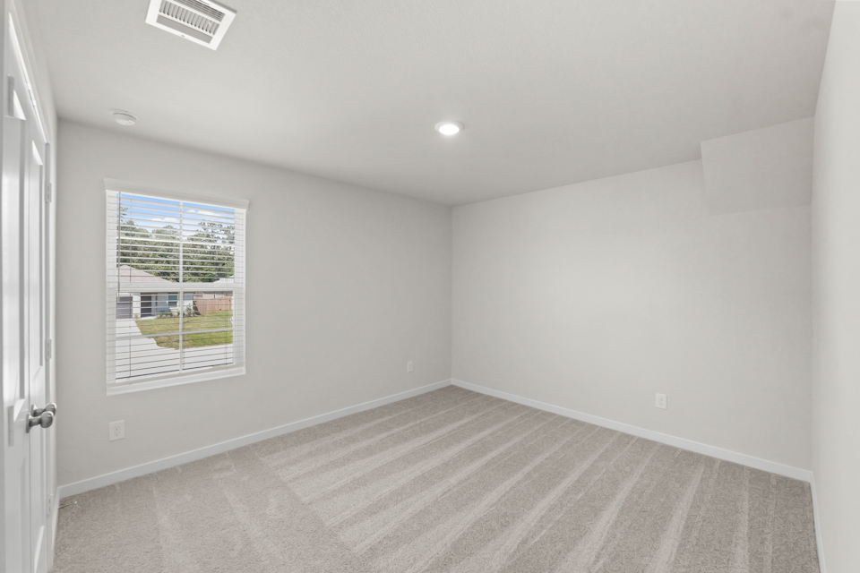 A room with a window and a rug.