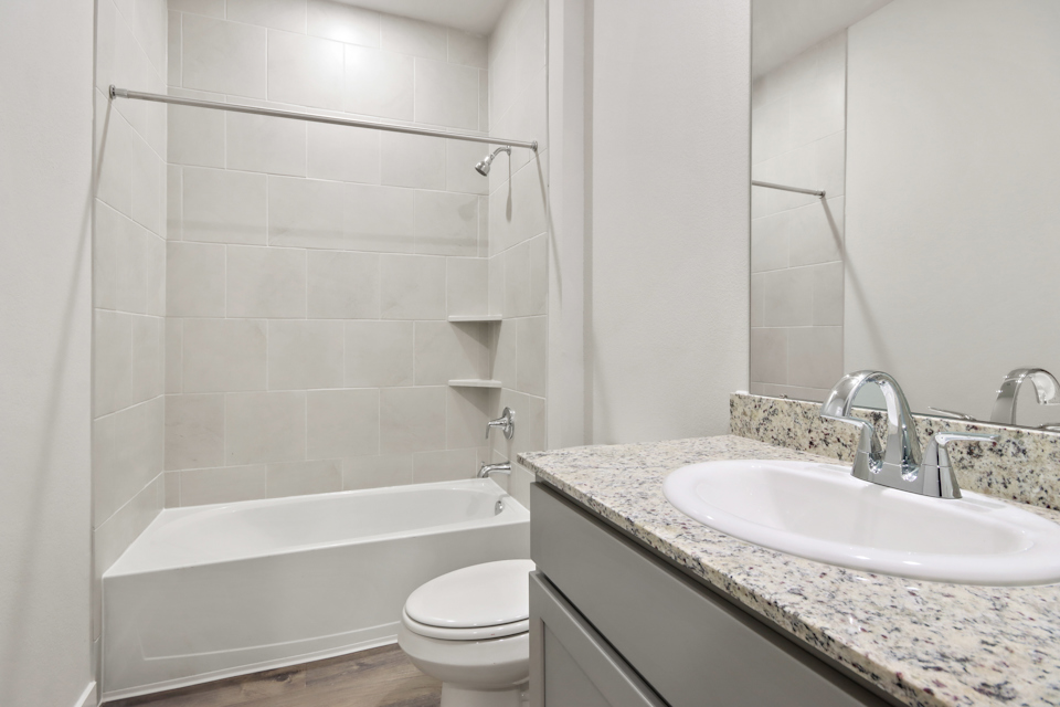 A bathroom with a tub sink and toilet.