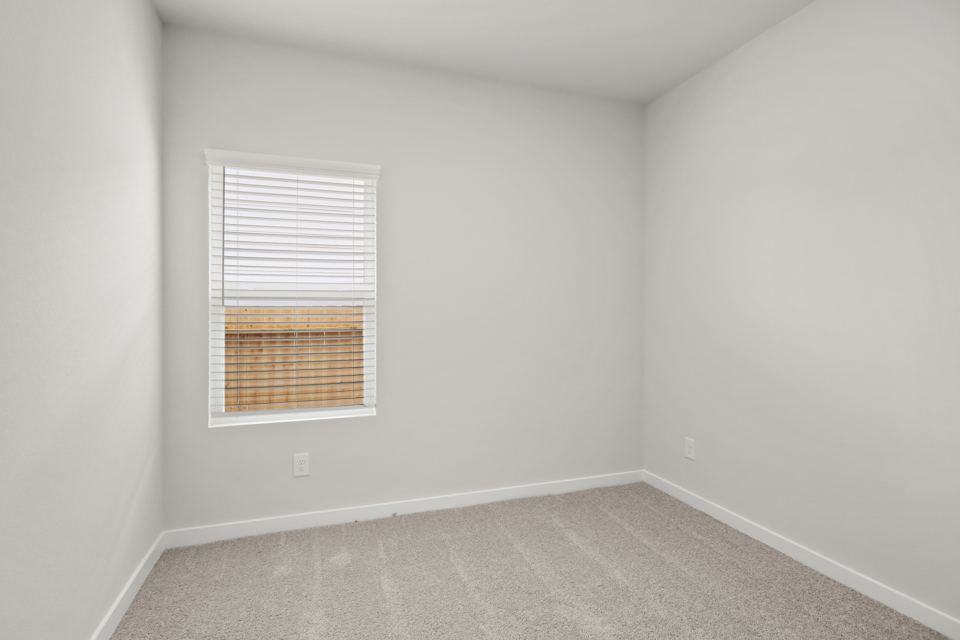 A room with a window and a rug.