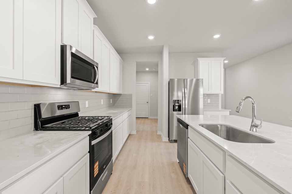 A kitchen with white cabinets.