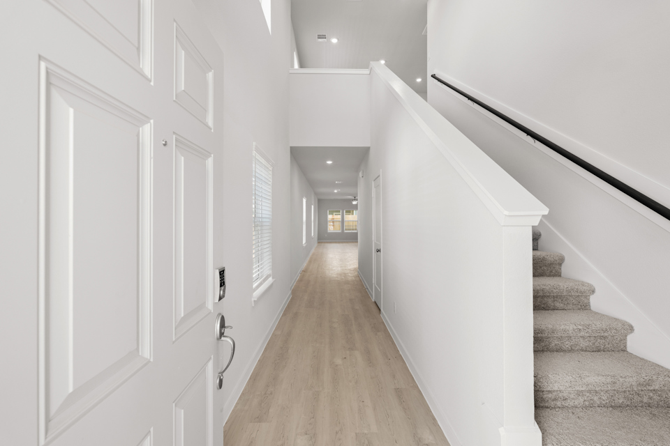 A long hallway with white doors.