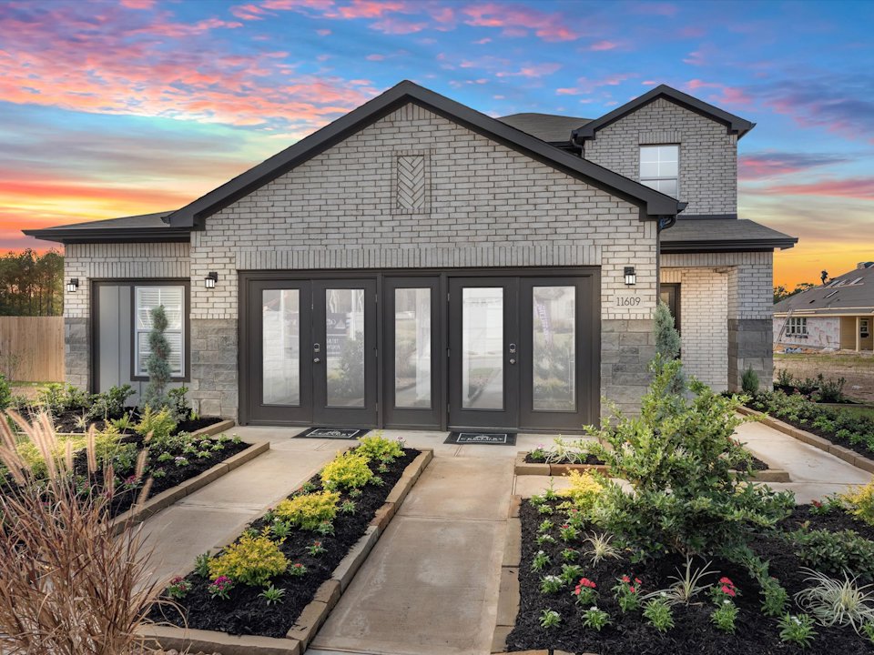 A house with a driveway and a garden in front of it.