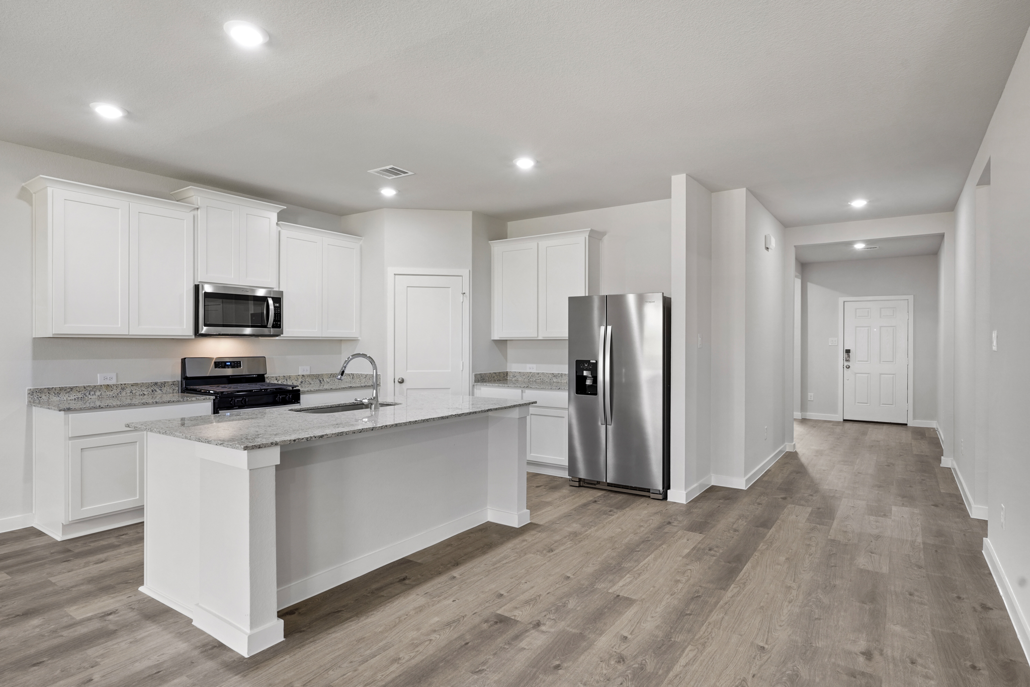 A kitchen with white cabinets.