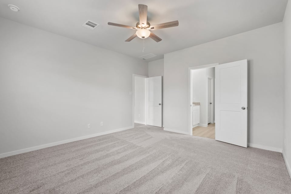 A room with white walls and a ceiling fan.