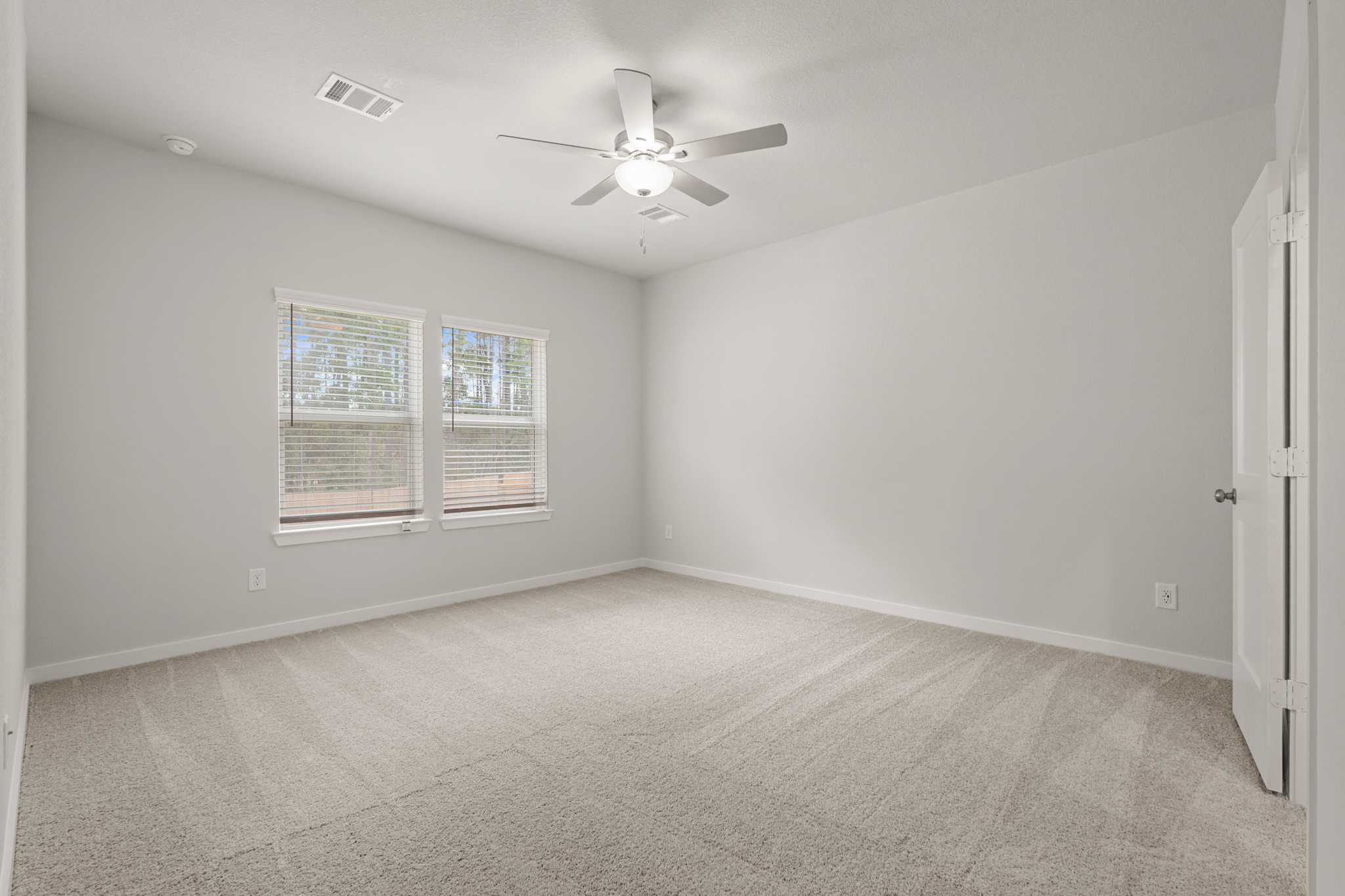 A room with a ceiling fan and a window.