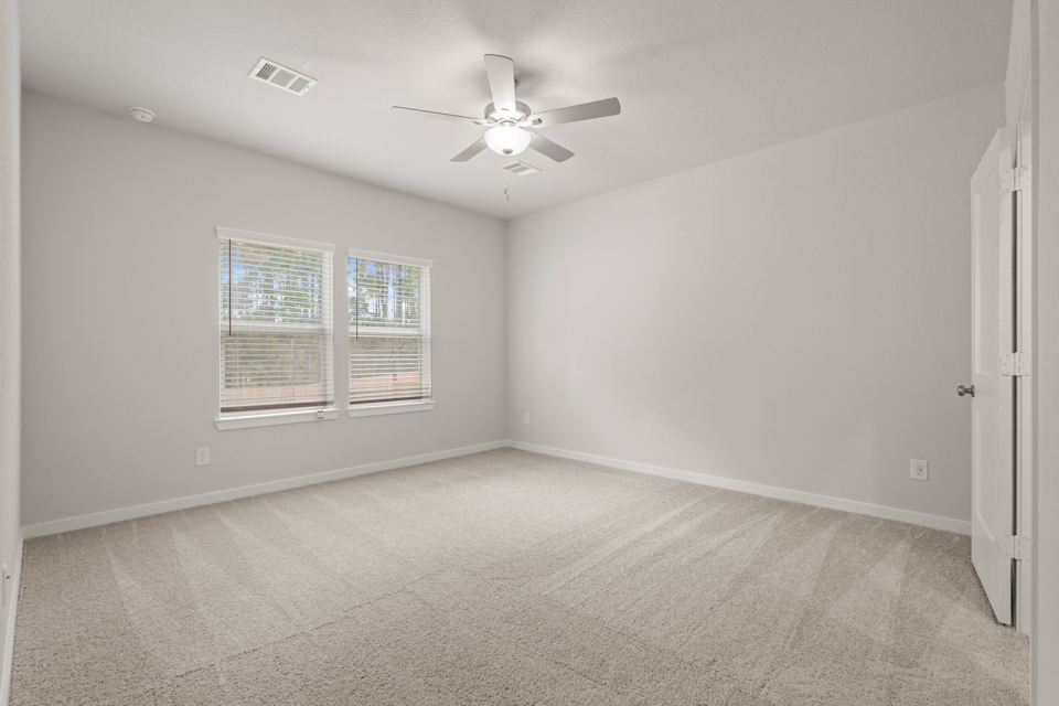A room with a ceiling fan and a window.
