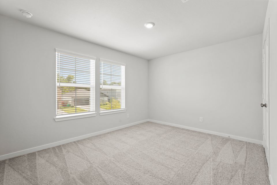 A room with a window and a carpet.