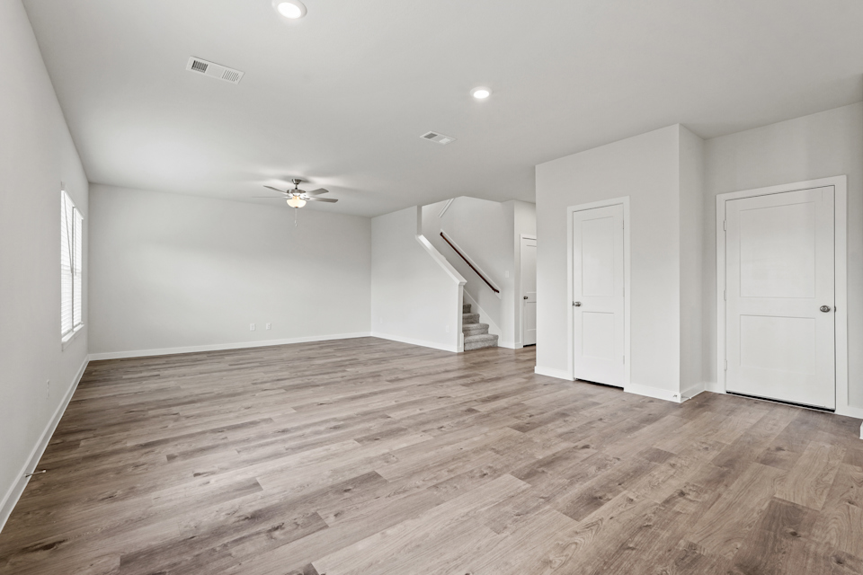 A room with white doors and a wood floor.