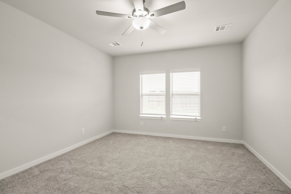 A room with a ceiling fan and a window.