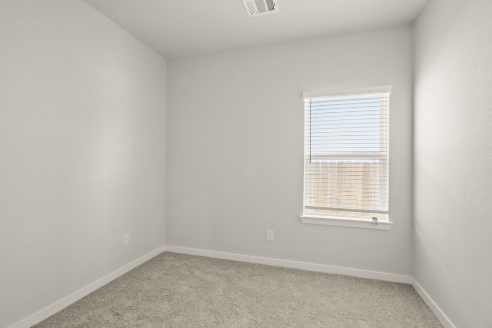 A room with a window and a carpet.