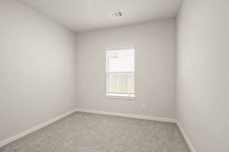 A room with a window and a carpet.