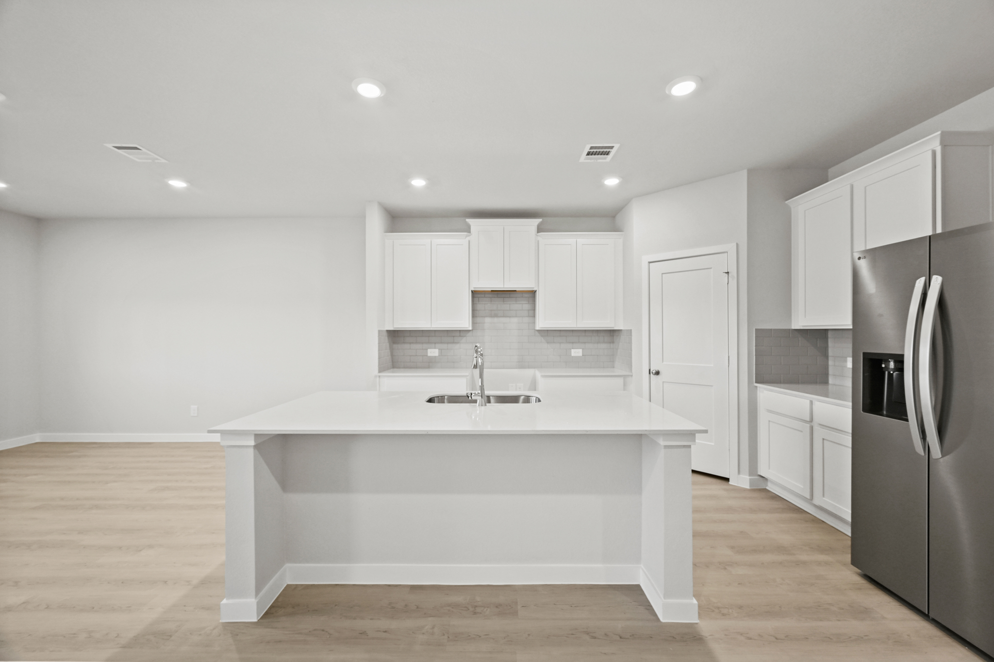 A kitchen with white cabinets.
