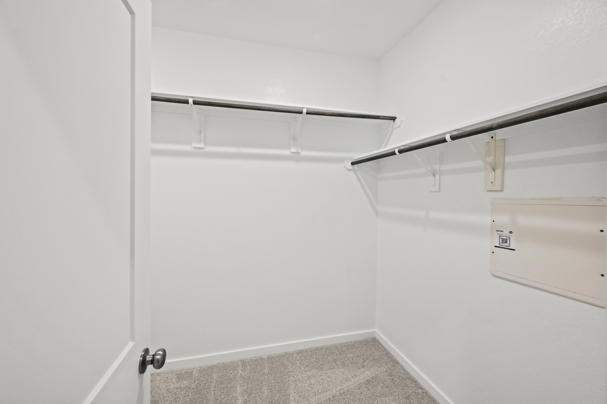 A white wall with a metal bar.