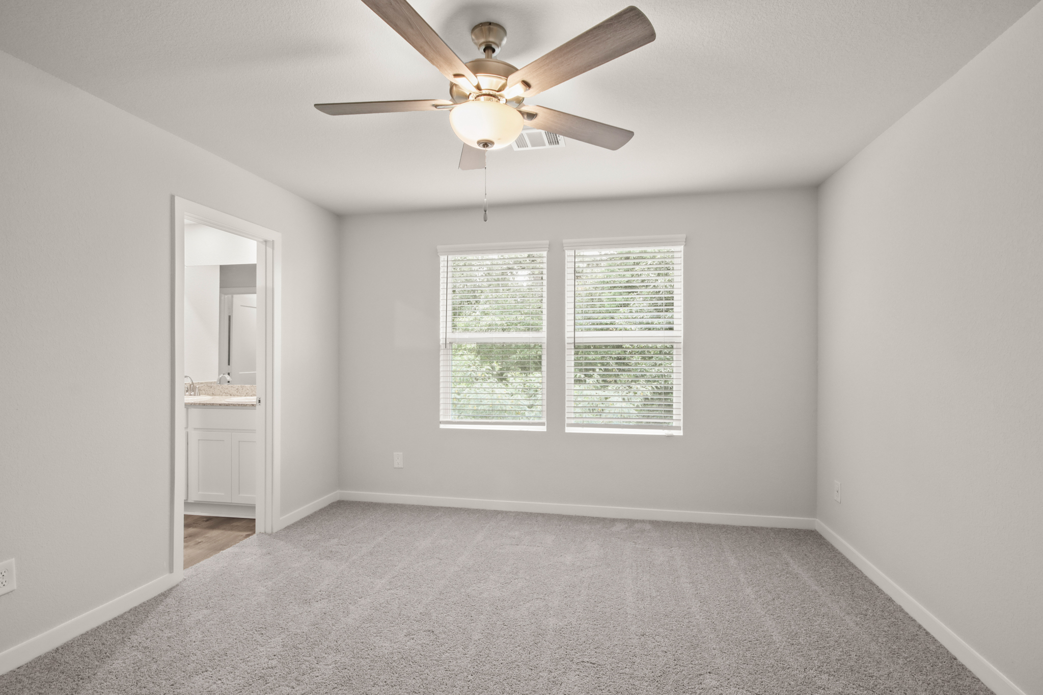 A room with a ceiling fan and a window.