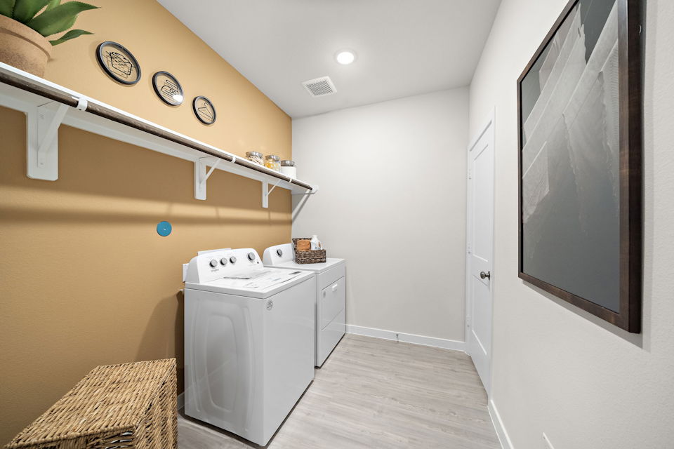 A room with a washing machine and a basket on the wall.