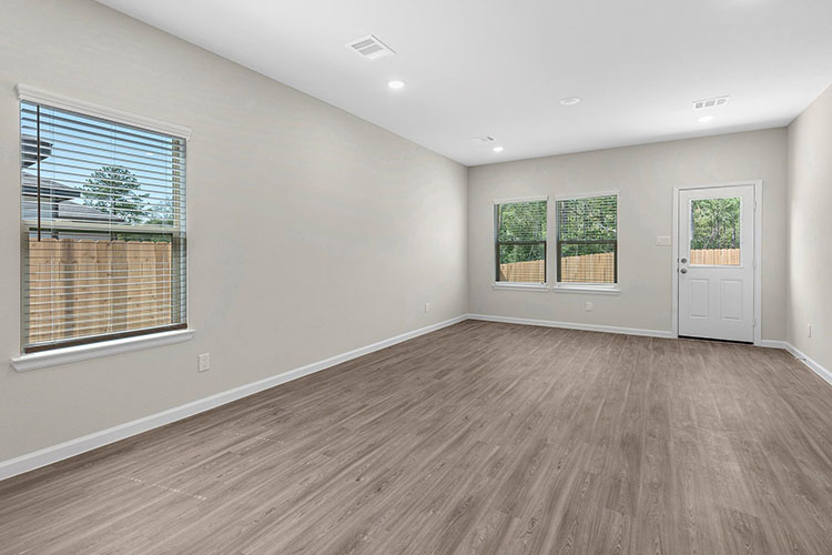 A room with a wood floor and windows.