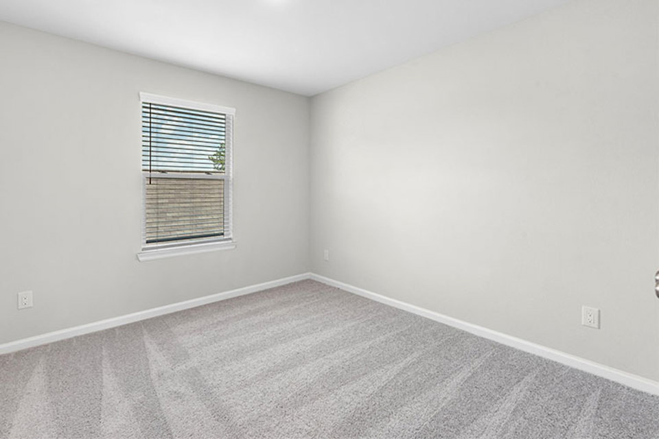 A room with a window and a carpet.