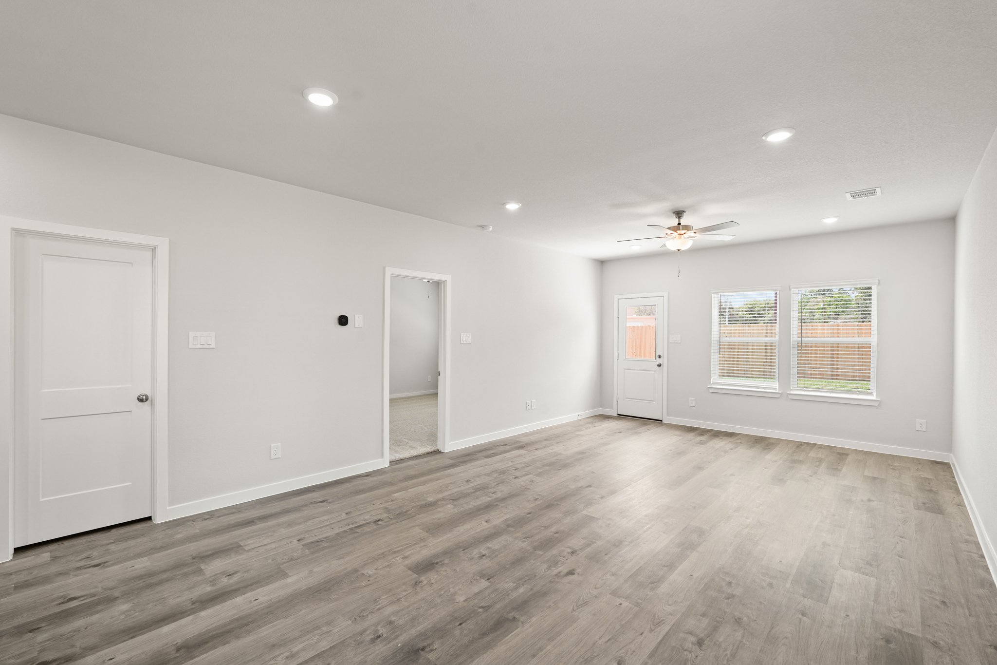 A room with a wood floor and white walls.
