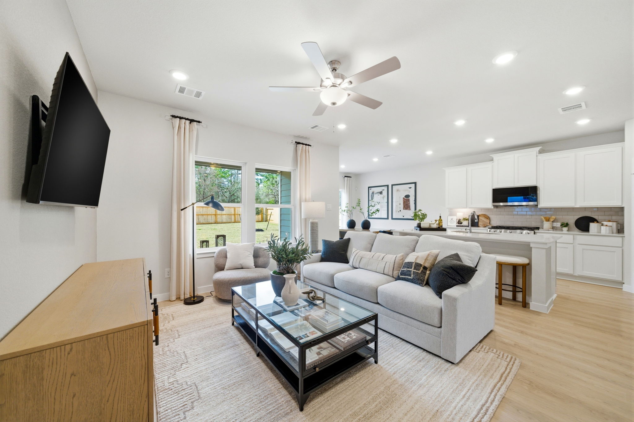 A living room with a large white couch and a tv.