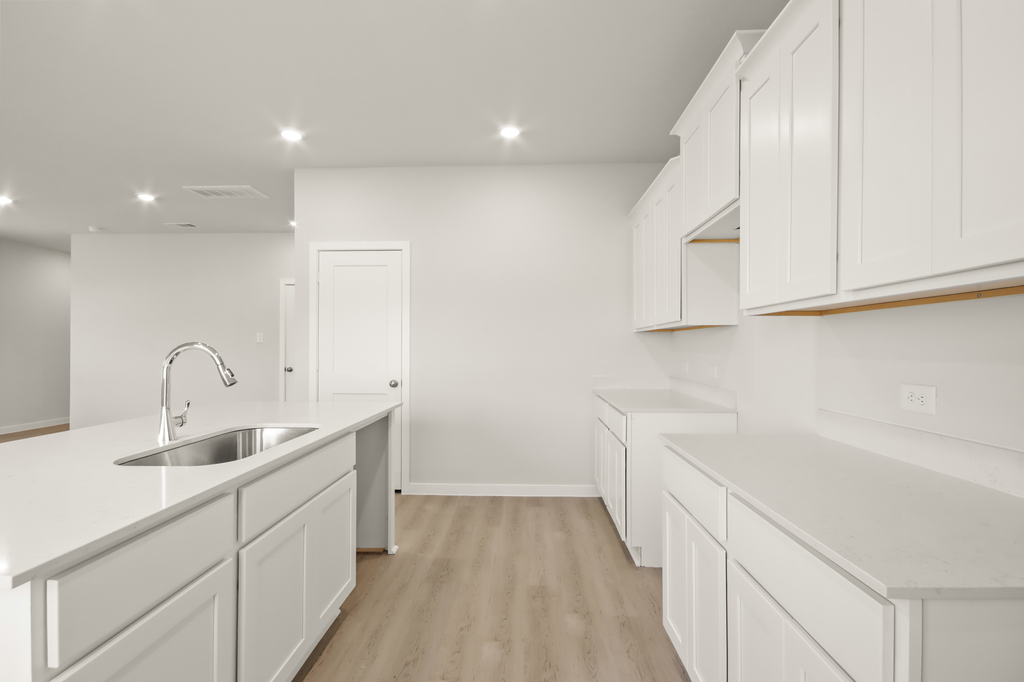 A kitchen with white cabinets.