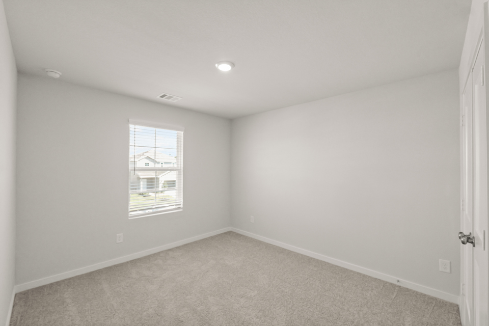 A room with a window and a carpet.