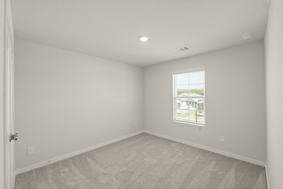 A room with a window and carpet.