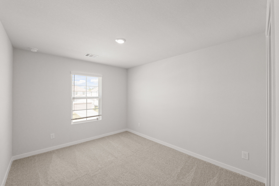 A room with a window and a carpet.