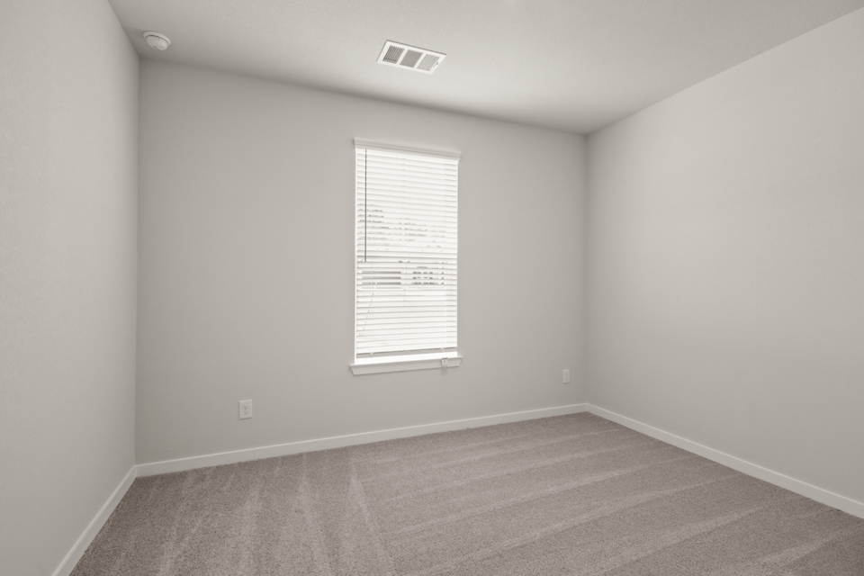 A room with a window and a carpet.
