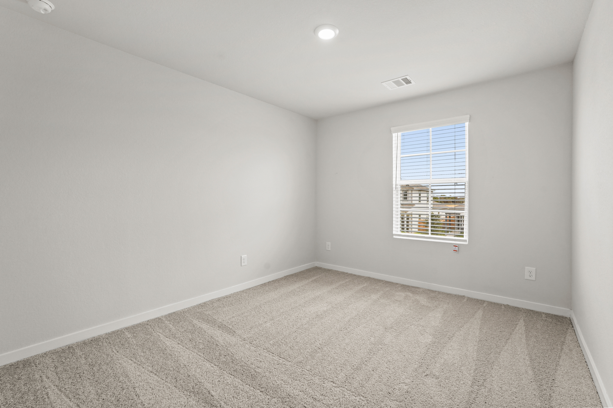 A room with a window and a carpet.