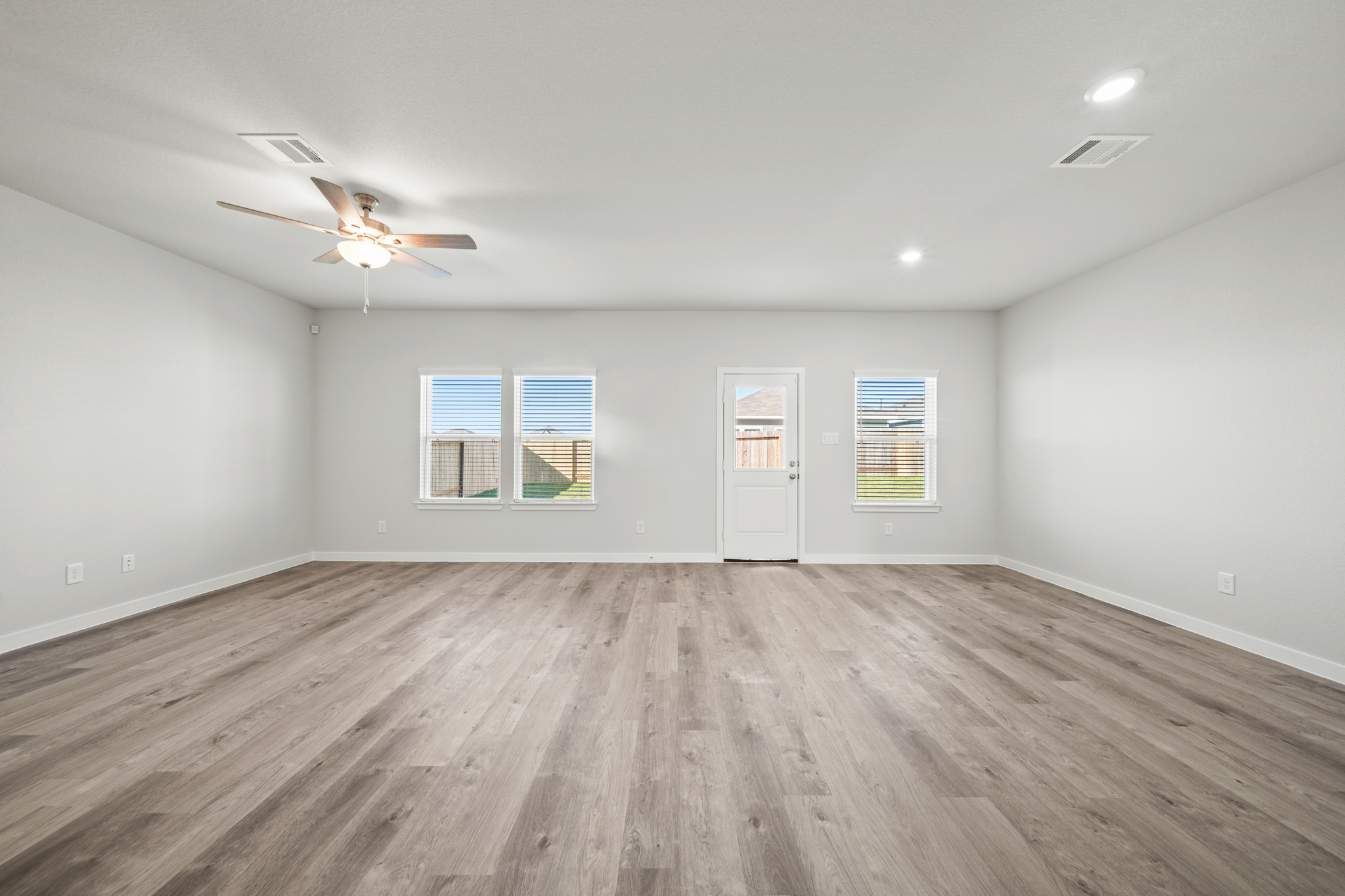 A room with a wood floor and a ceiling fan.