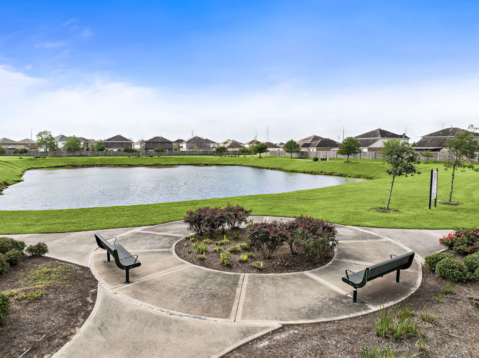 A pond with benches and a path.