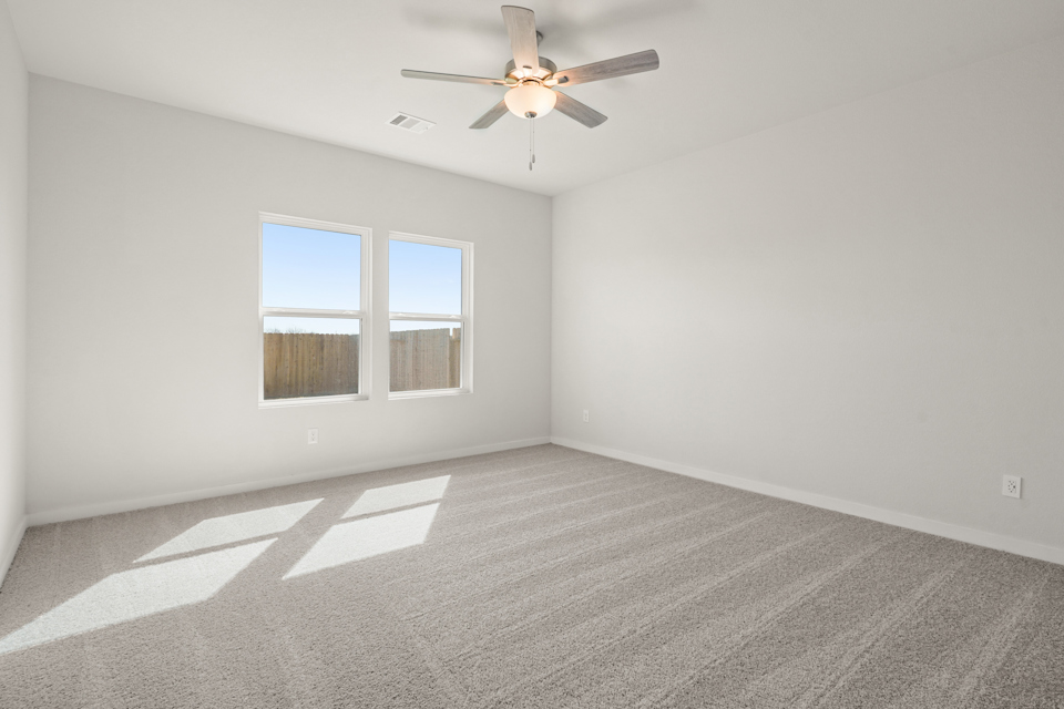 A room with a ceiling fan and a window.