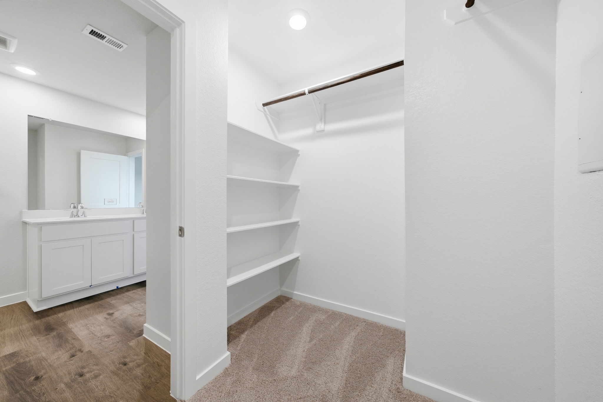 A white bathroom with a white shelf.