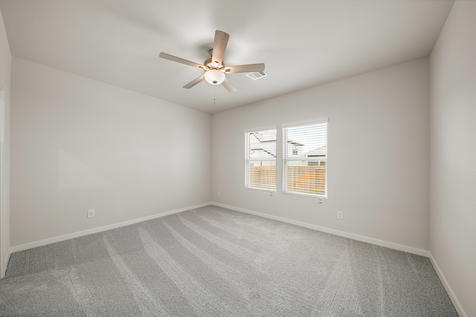 A room with a ceiling fan and a window.